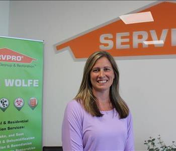 woman in front of a SERVPRO office backdrop