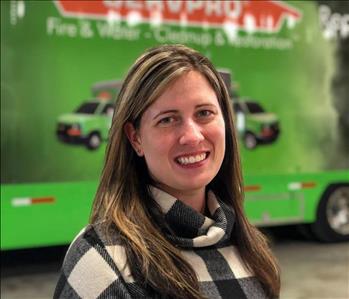 woman in front of a SERVPRO trailer