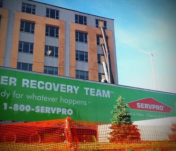 Commercial multi-story building with a SERVPRO 53' semi trailer parked in front of it.